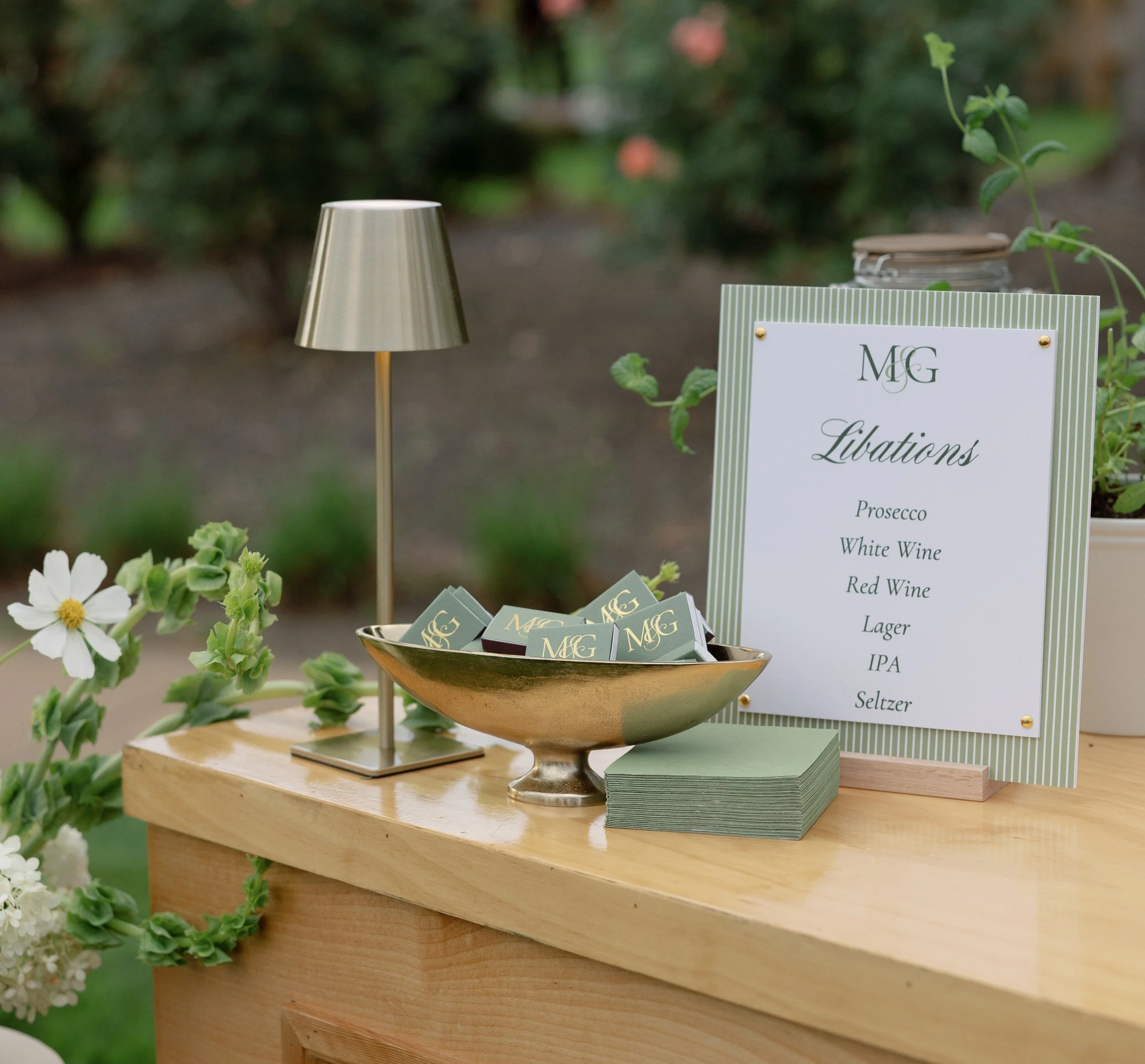 Wood wedding bar with bar menu and gold vessel with monogrammed matchbooks