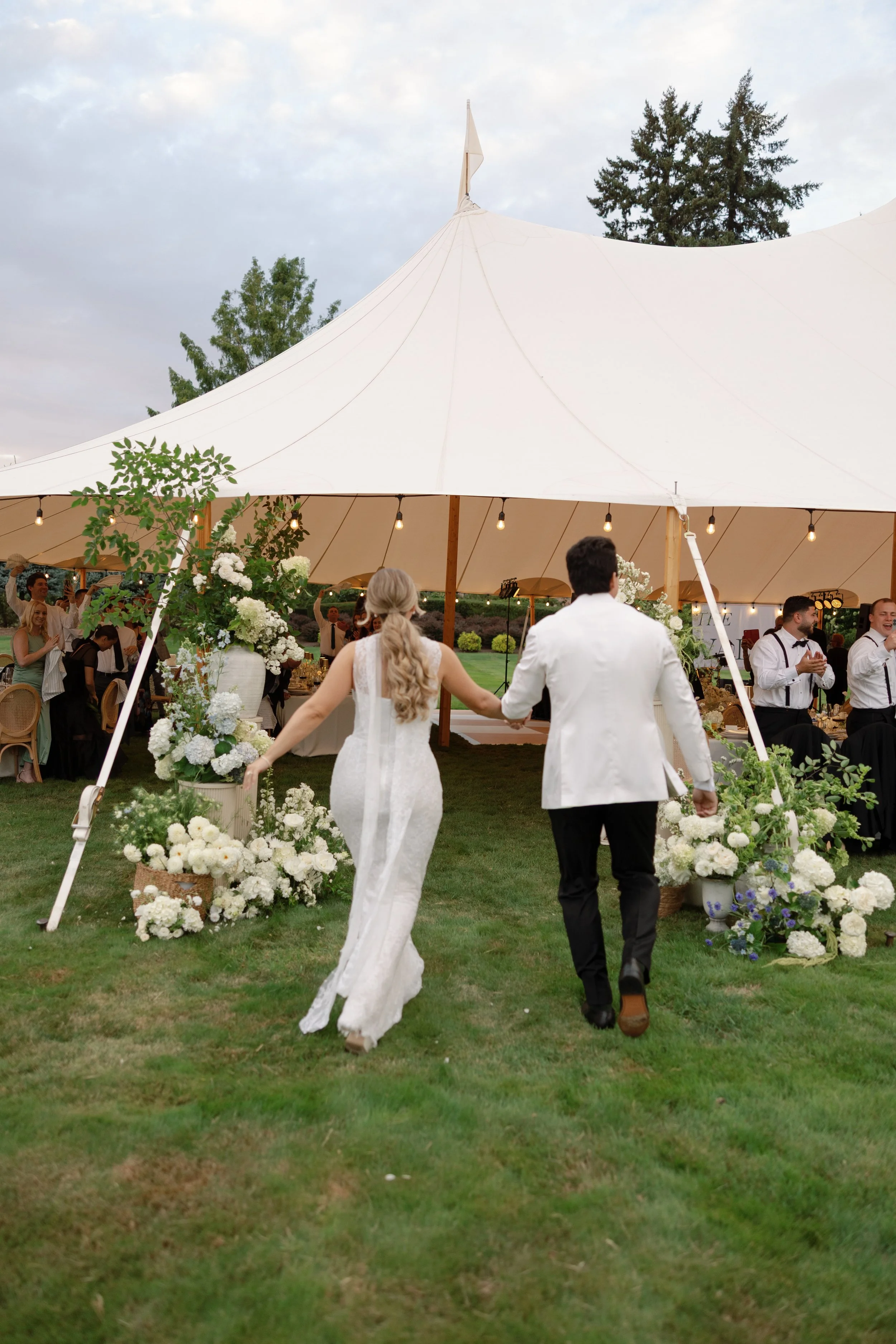 Bride and groom grand entrance to reception in Sperry tent