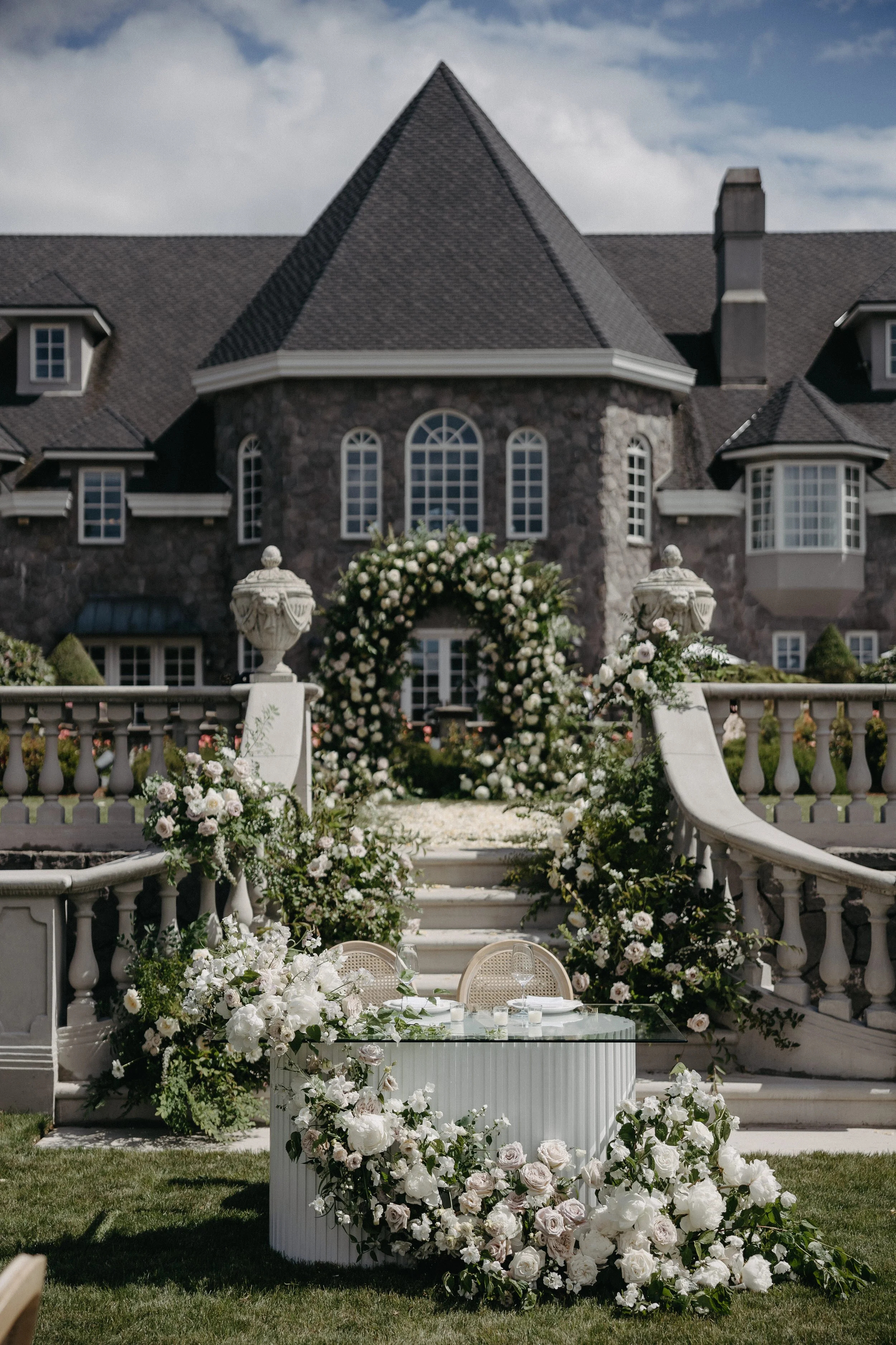white ribbed wood sweetheart table with lush floral swag of green and white florals