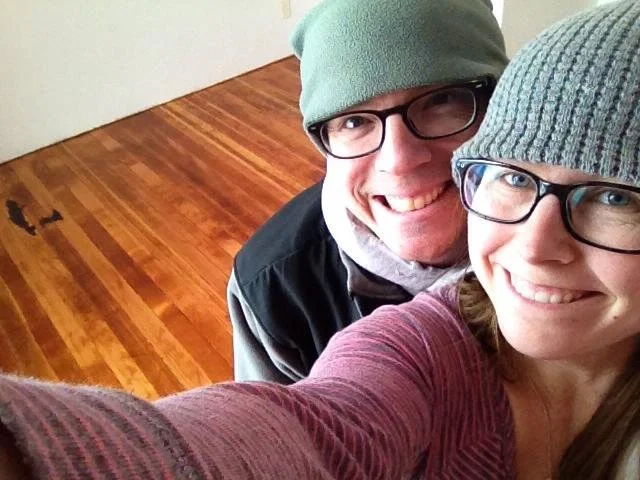 a man and a woman standing on a recently refurbished old wood floor