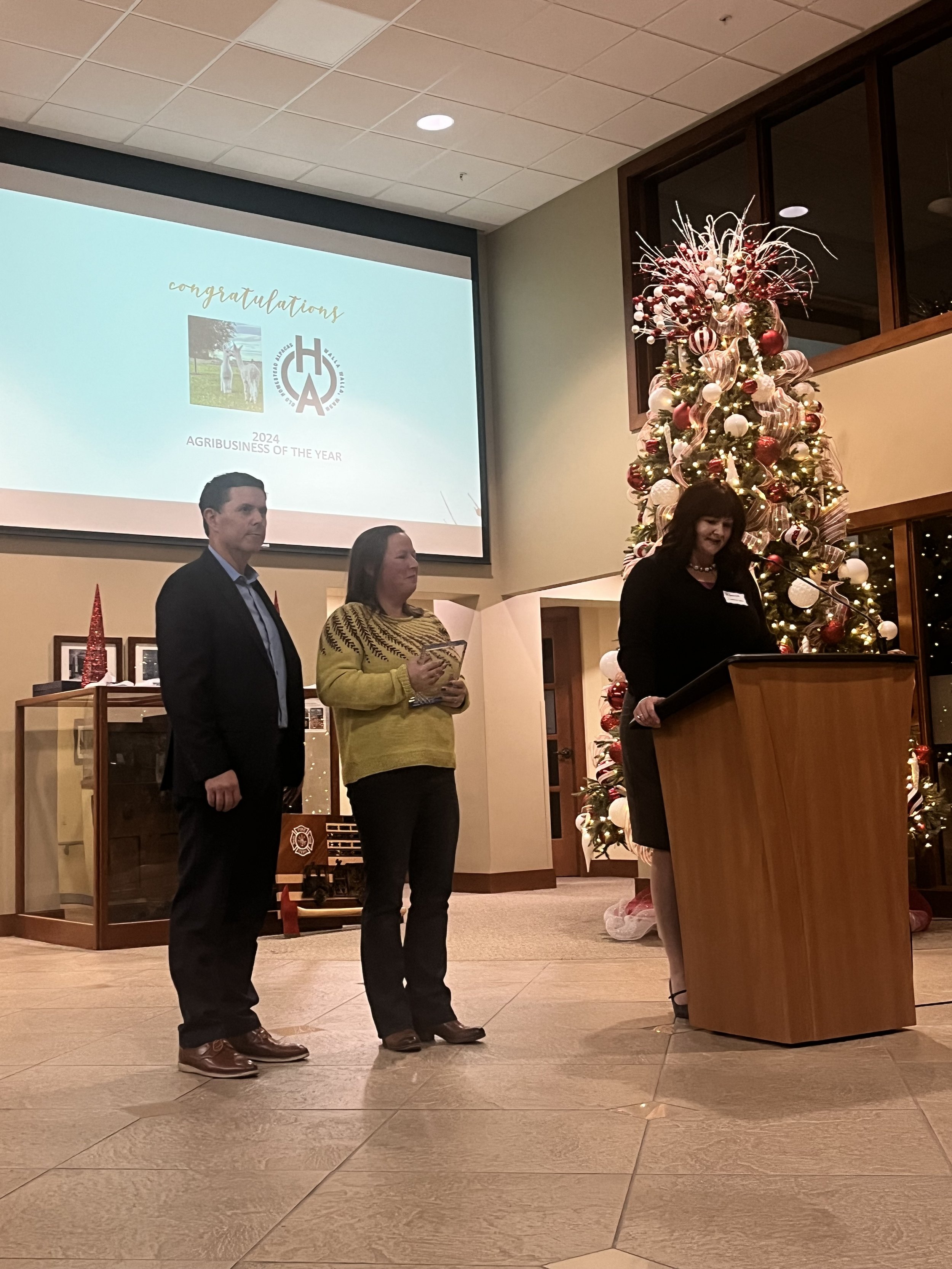 Farmer receiving award for the Agribusiness of the Year in the bank lobby with a Christmas tree in the background