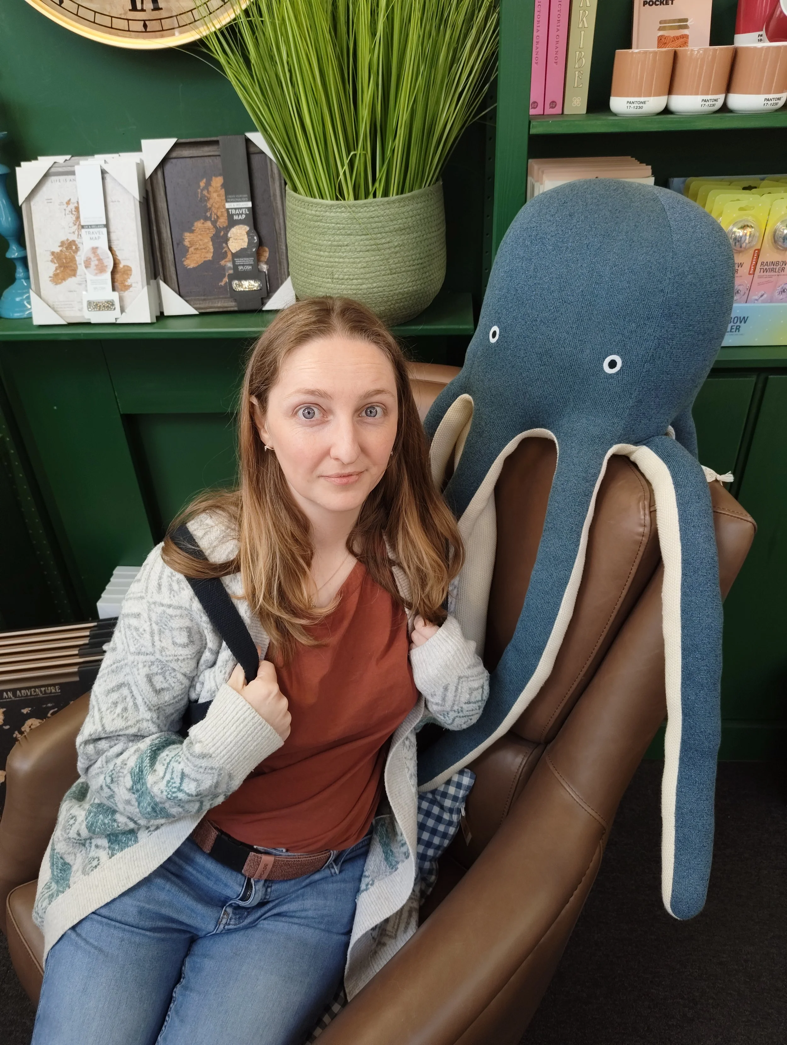 Blonde woman with big blue eyes next to a a big blue stuffed octopus.