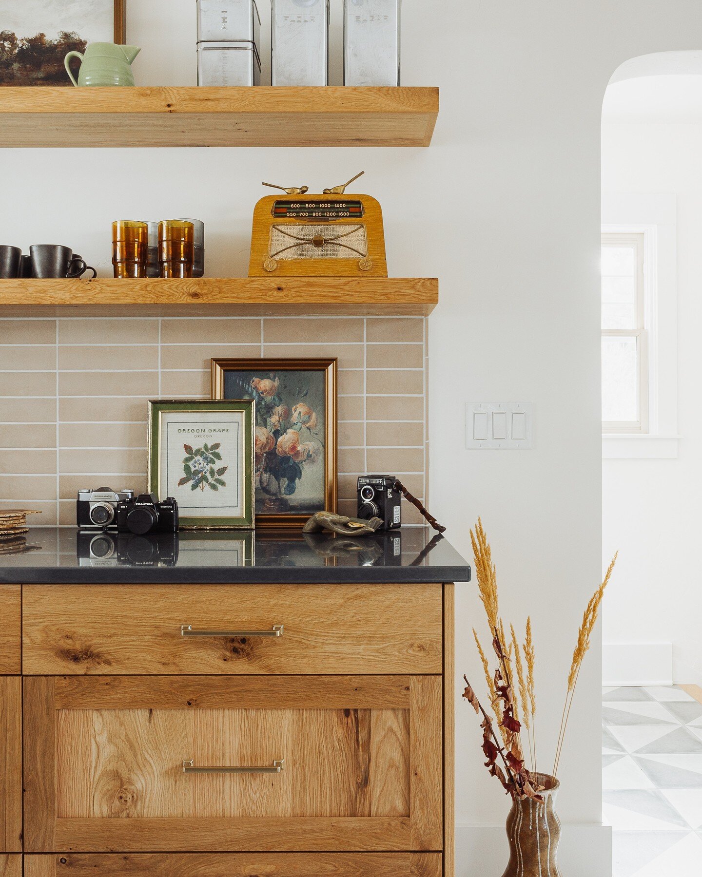 A &quot;hutch nook&quot; created a dedicated area for coffee, tea, art, and collectibles. Open shelving kept the small space light and airy. Swipe to see before.

Photo by: @gallivancreative
Styling: Jenny Andrews

#bendremodel #millhouse