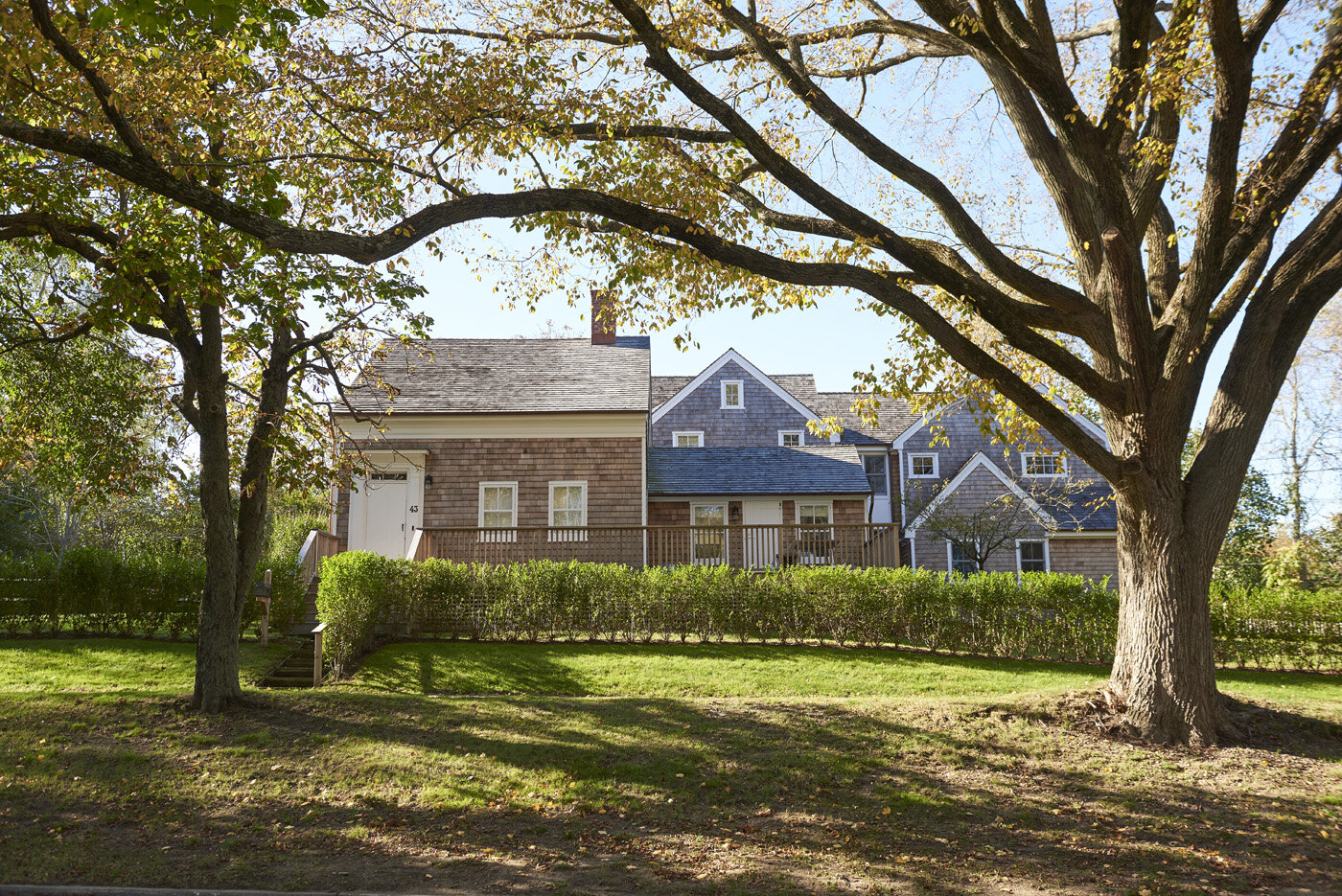  View of a Hamptons home from the front, showing the front landscaping designed by Hamptons architect Ernest Schieferstein. 