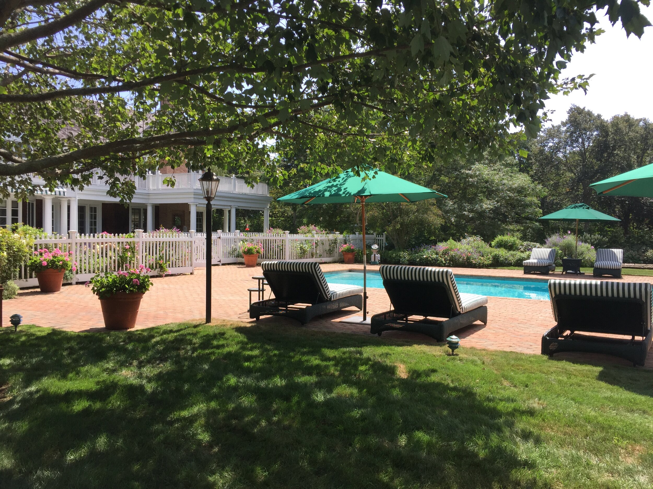 View of Hamptons shingle style home from back patio by Hamptons architect Ernest Schieferstein