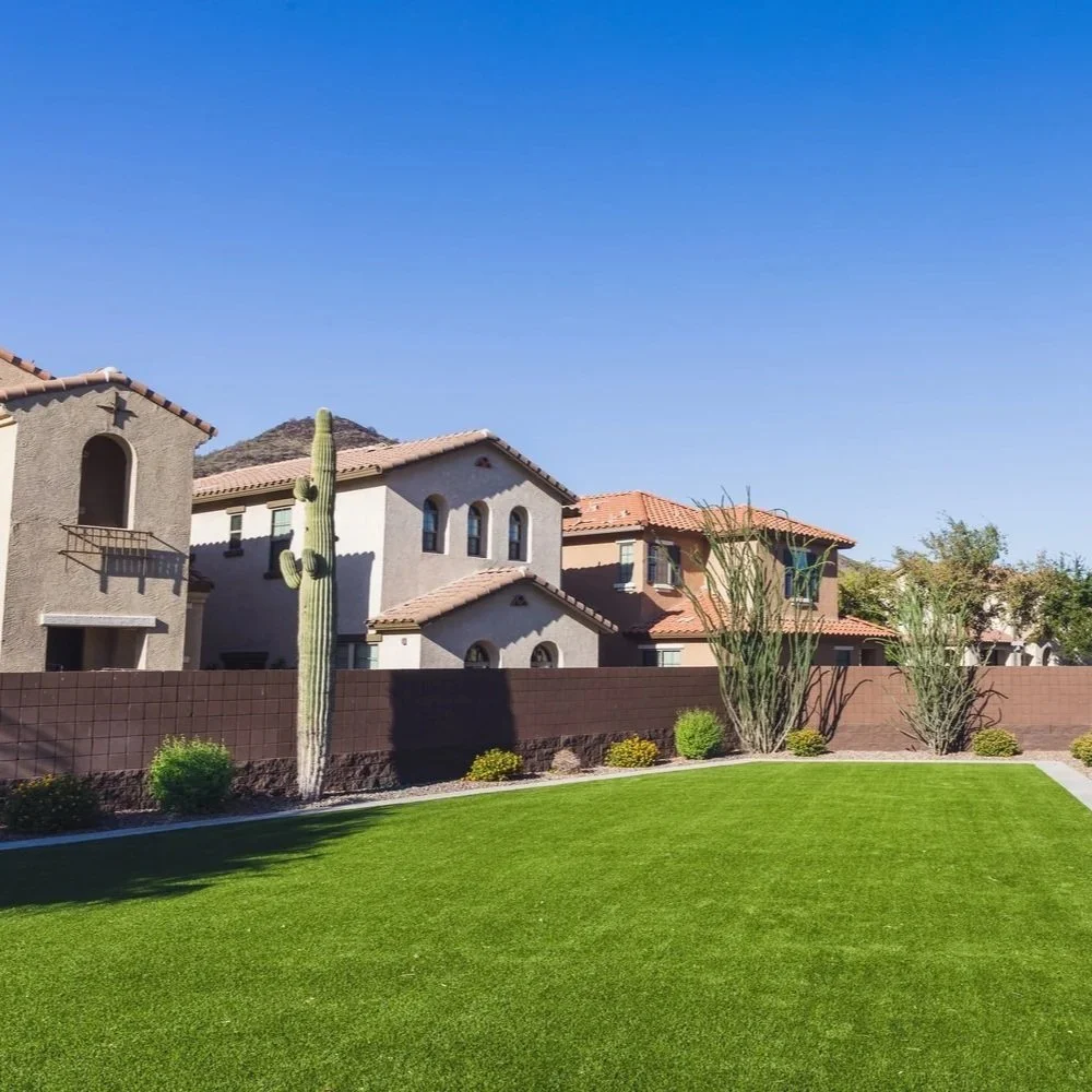 Lush green artificial turf playground at a Phoenix school, showcasing water conservation and sustainable landscaping in a dry desert climate.