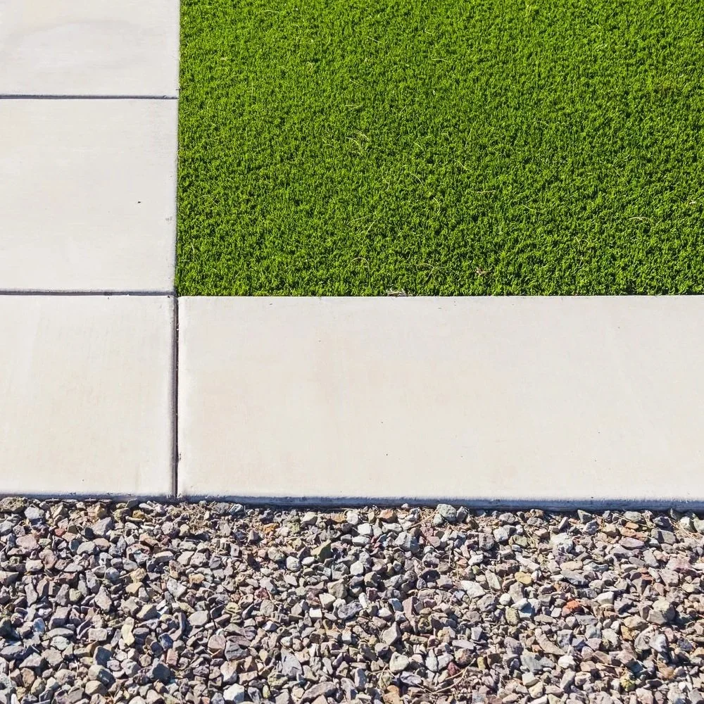 A professional administrator reviews a safety checklist while standing on a newly installed, vibrant green artificial grass school playground area.