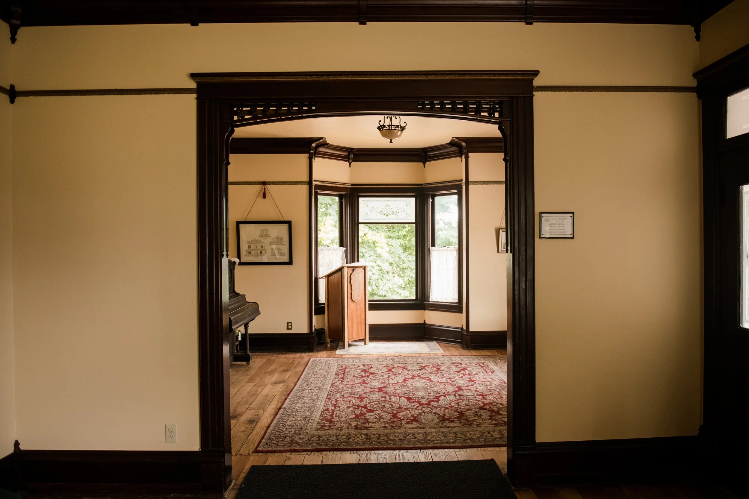 View looking from the south parlor into the north parlor of the 1903 Brown House in Stayton, Oregon. Ornate trims are notable throughout the rooms.