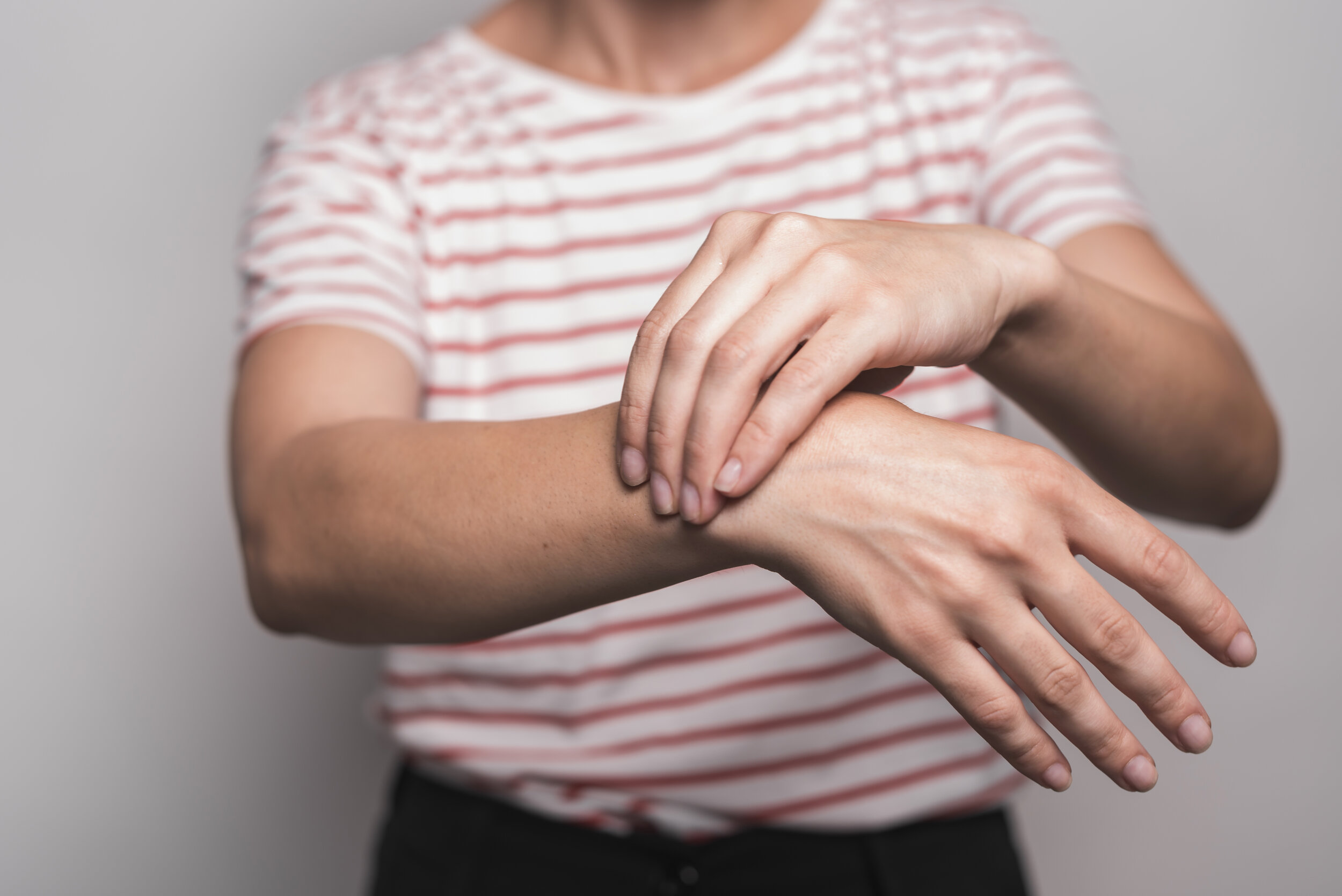 close-up-woman-having-wrist-pain-standing-against-gray-background.jpg
