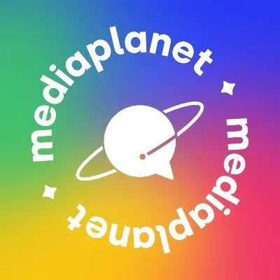 Colorful background with the text 'mediaplanet' curving around a stylized white planet with a ring and a small flag, emphasizing a space or global theme.