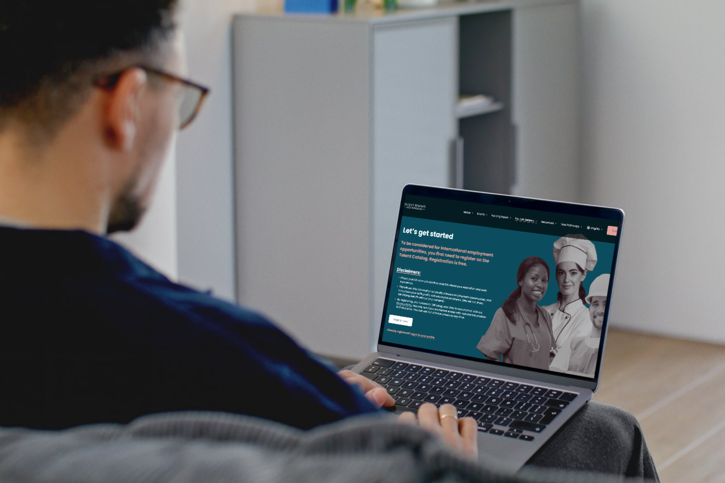 Man working on a laptop, screen displaying TBB's Talent Catalog registration page.