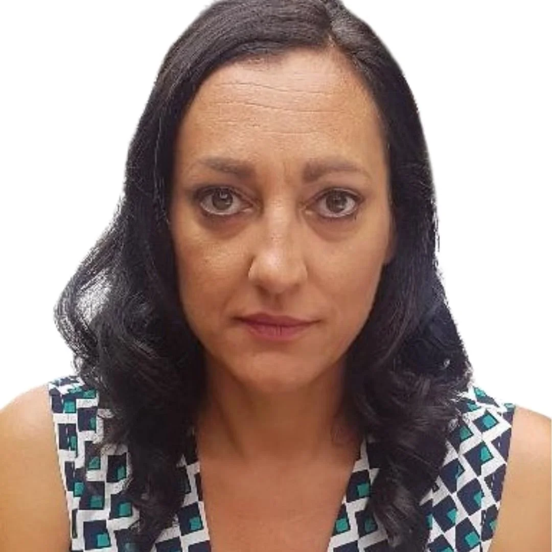 Portrait of a woman with shoulder-length dark hair, wearing a sleeveless dress with a geometric pattern, against a plain white background.