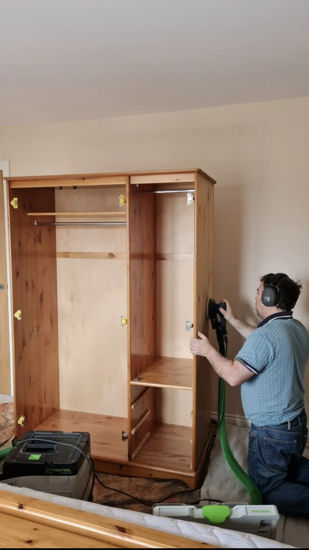 Sanding pine wardrobe on site.jpg