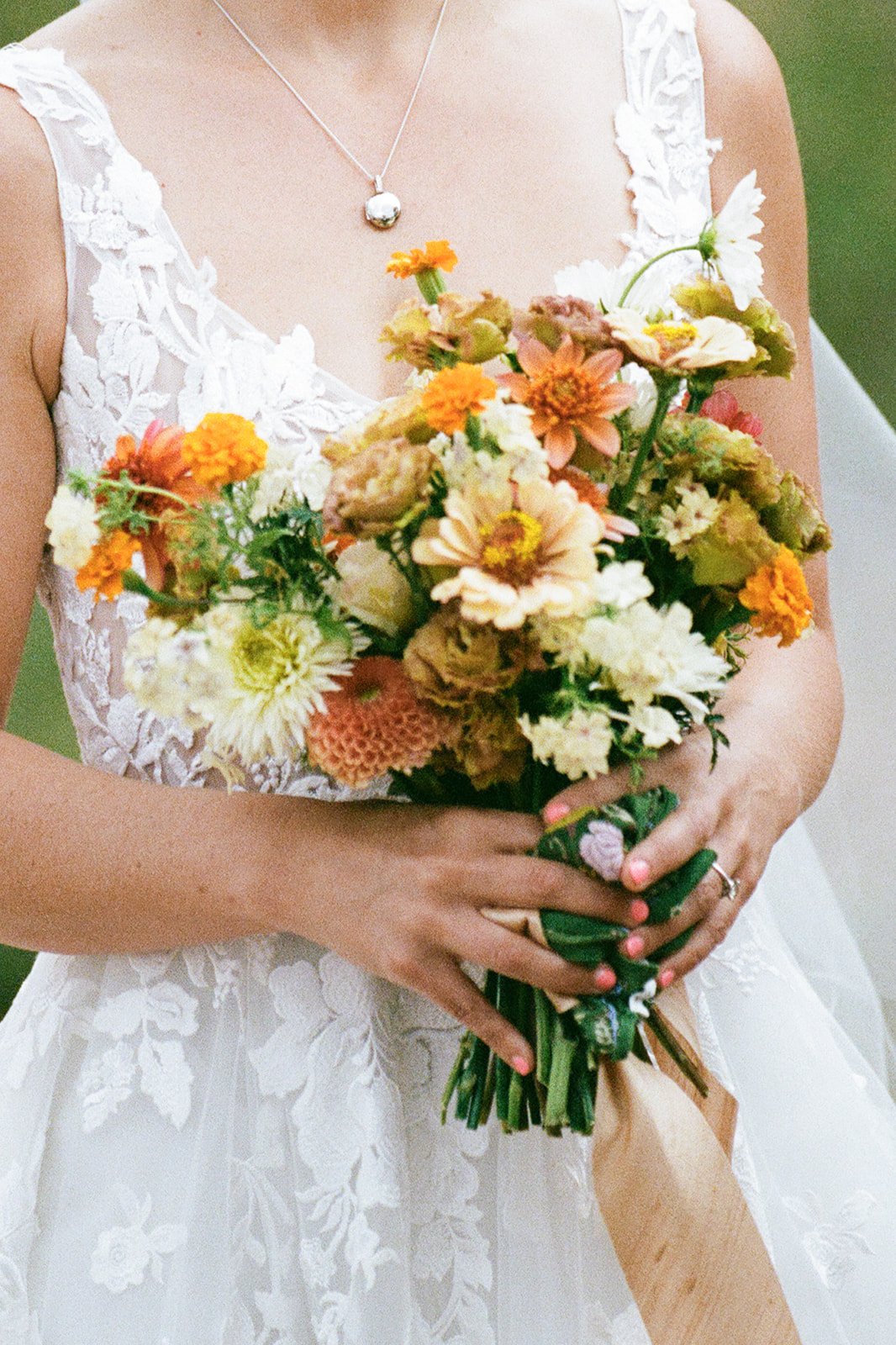 Farm Yard - Moab Utah - A woman in a white lace dress holding a bouquet of mixed flowers.