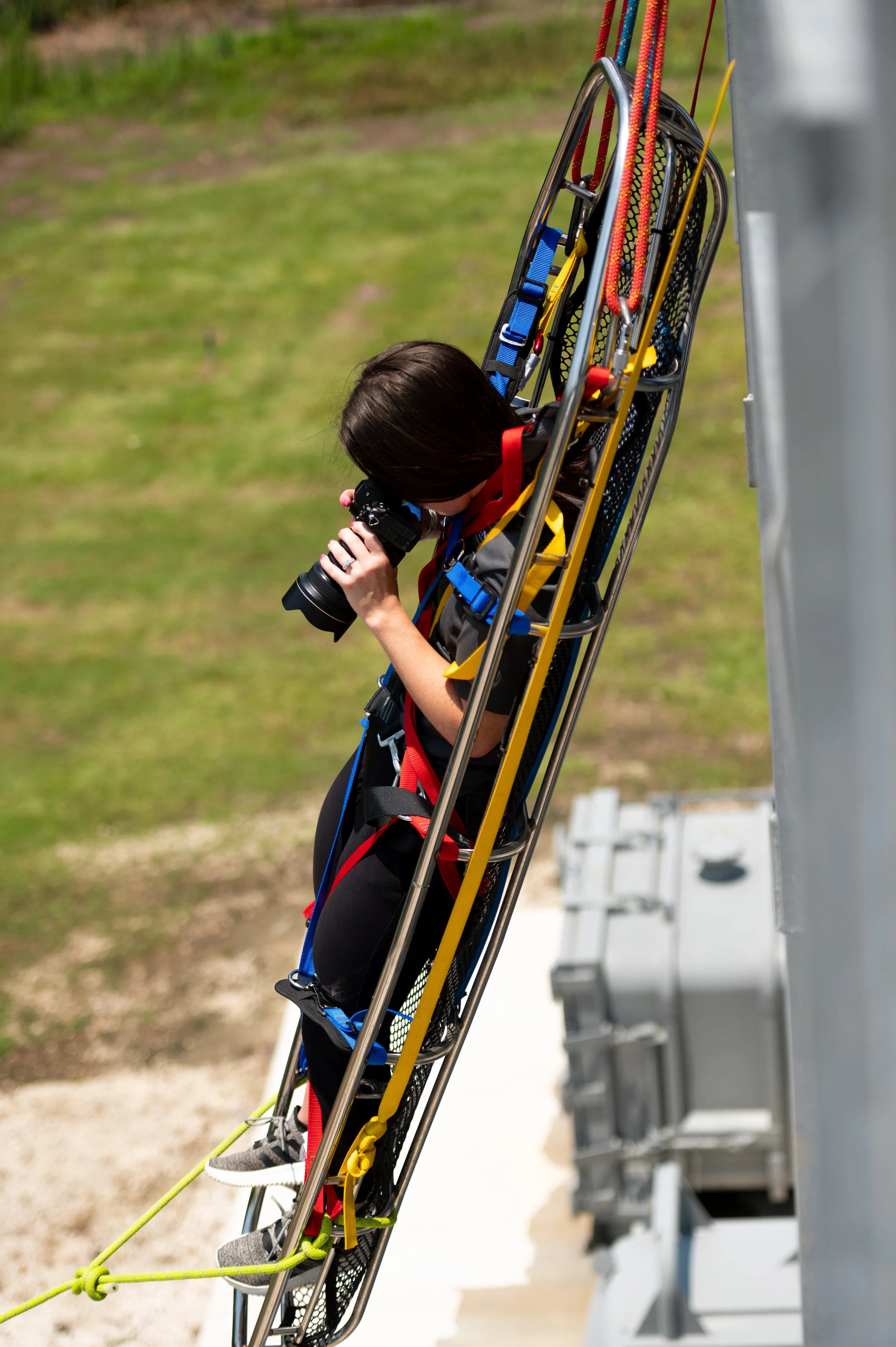 Flash Forward photographer suspended in safety equipment while documenting industrial rope rescue training.