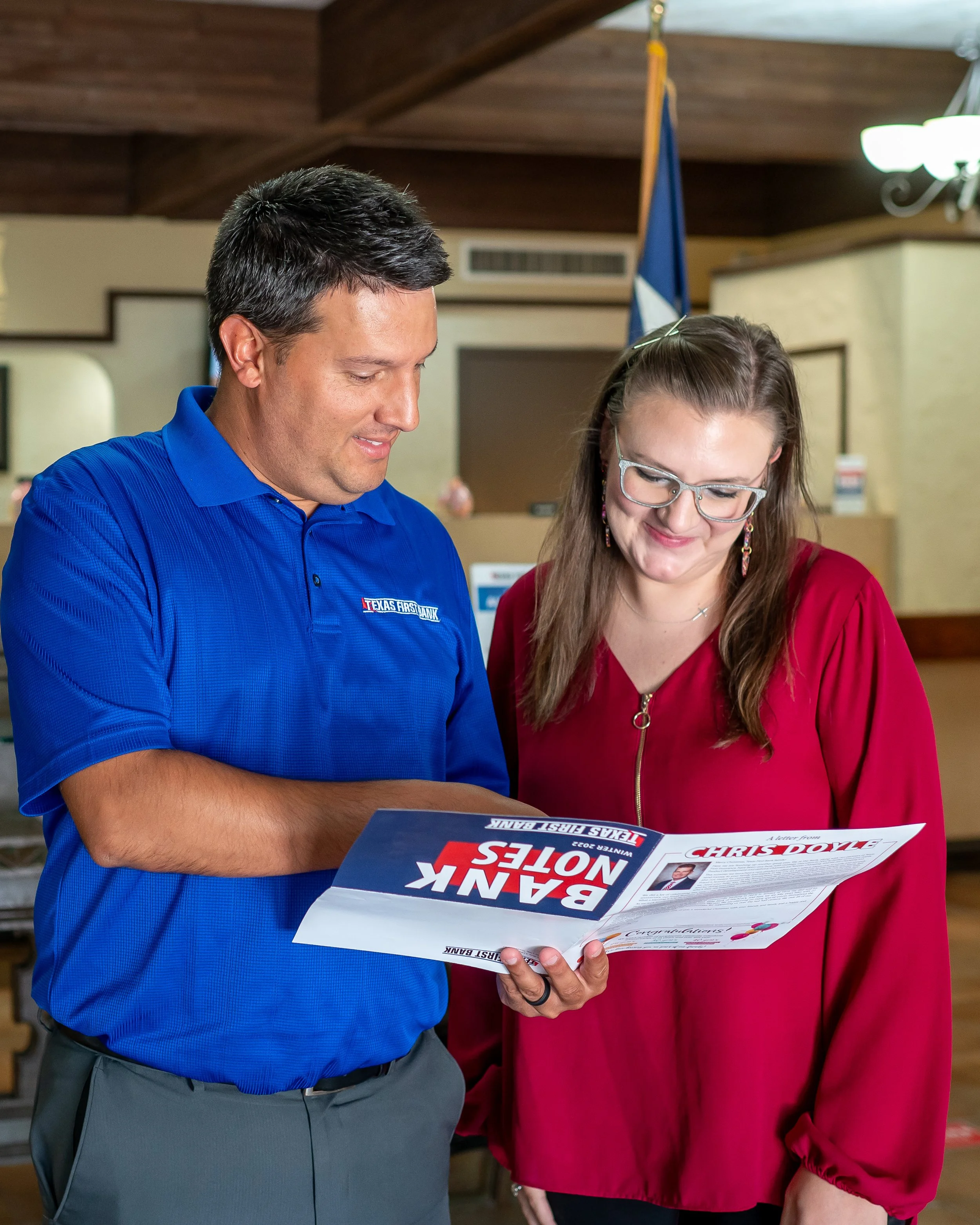 Two professionals reviewing printed marketing materials during a corporate branding photography session.