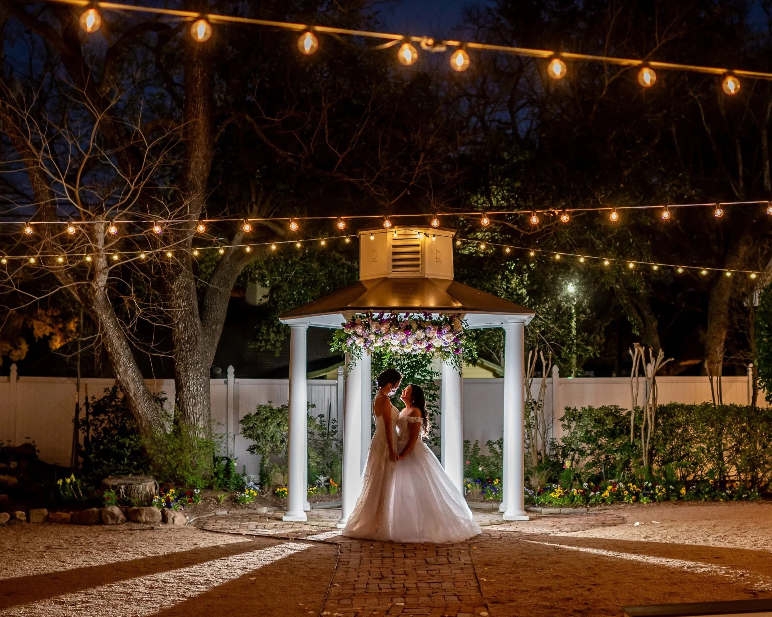 Night wedding ceremony at Butler’s Courtyard in League City Texas with gazebo, string lights, and florals by Lush Flowers