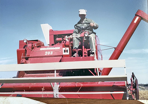 A man driving a red tractor.