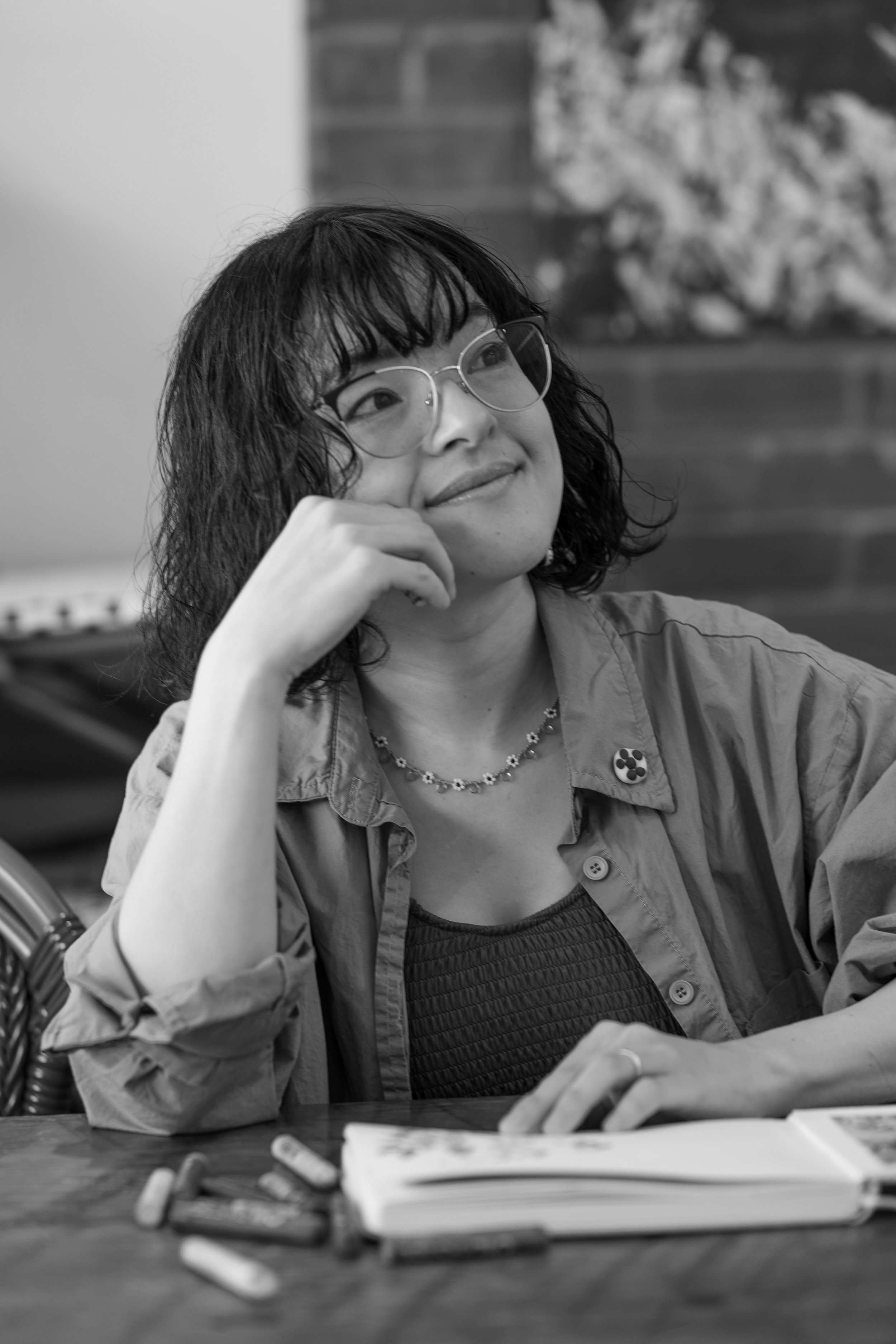 Chikako Ogawa rests her chin on her hand. She is smiling slightly.