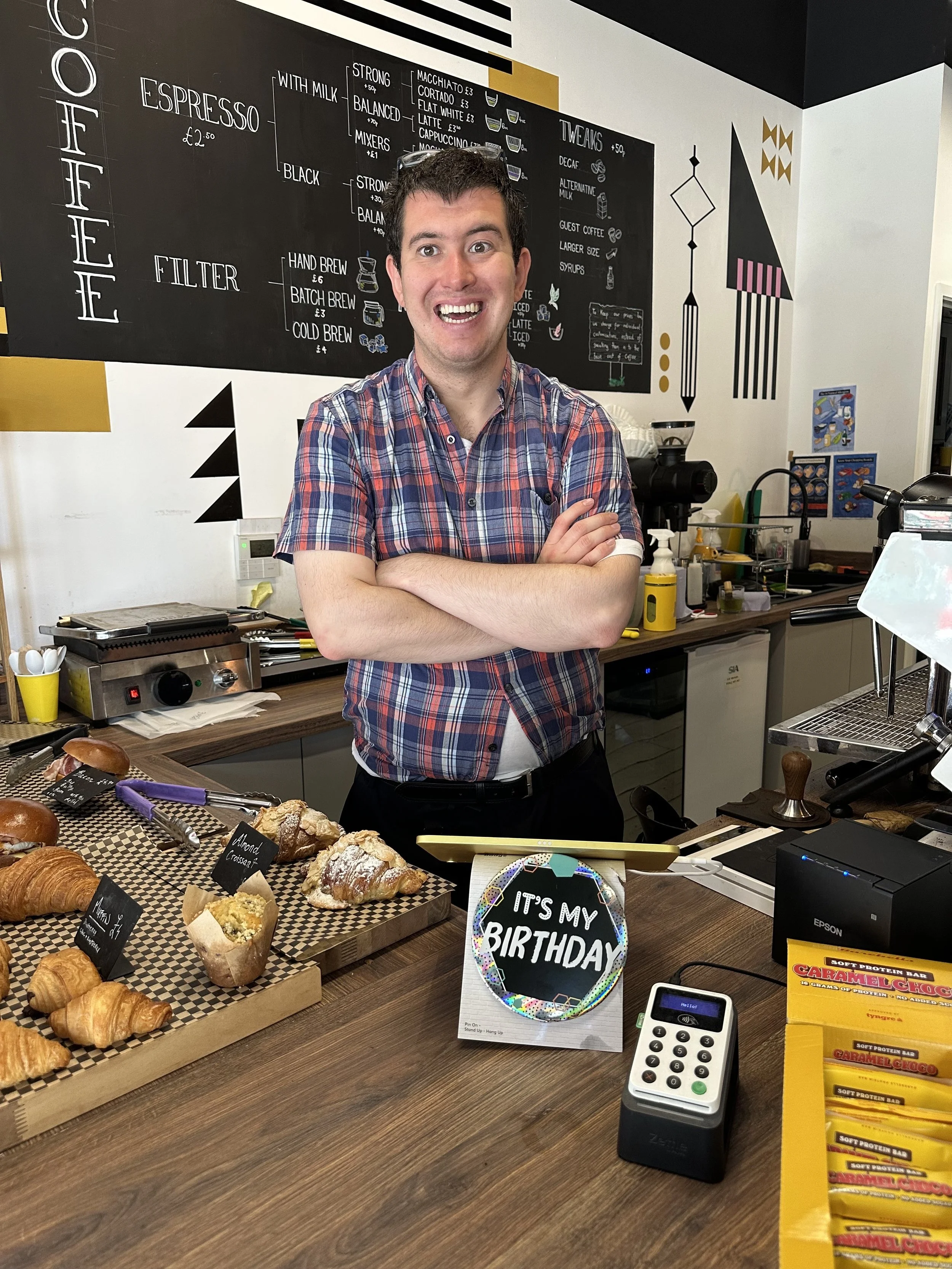  A man standing behind the bar at a coffee shop 