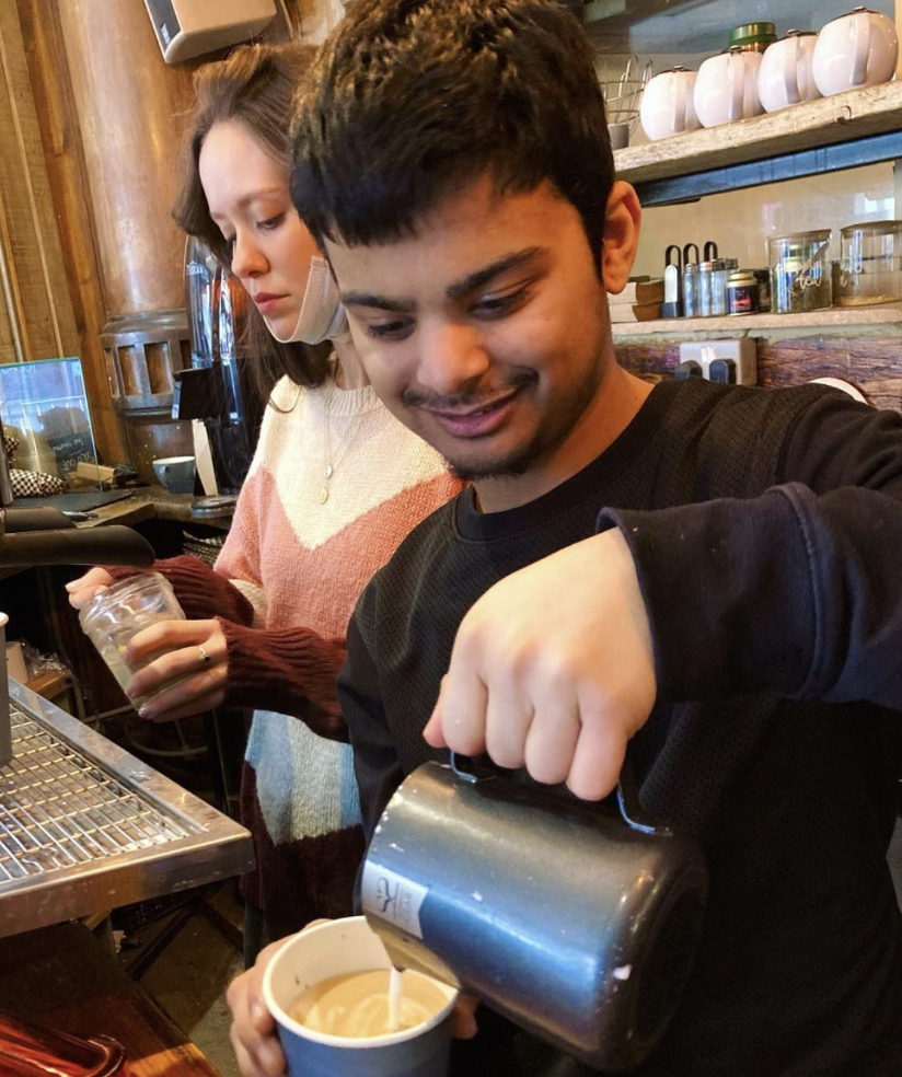 A photograph of a person pouring latte art 