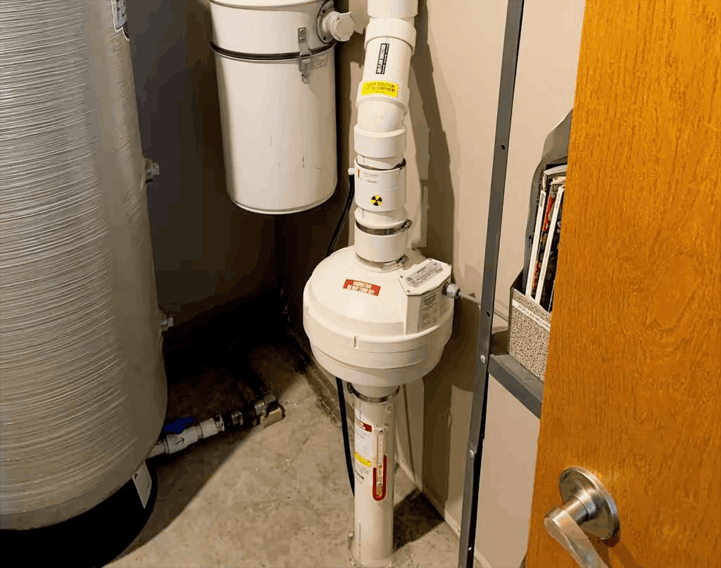 Radon mitigation system installed in the basement of a home in Winnipeg including a FanTech Fan and pipe.