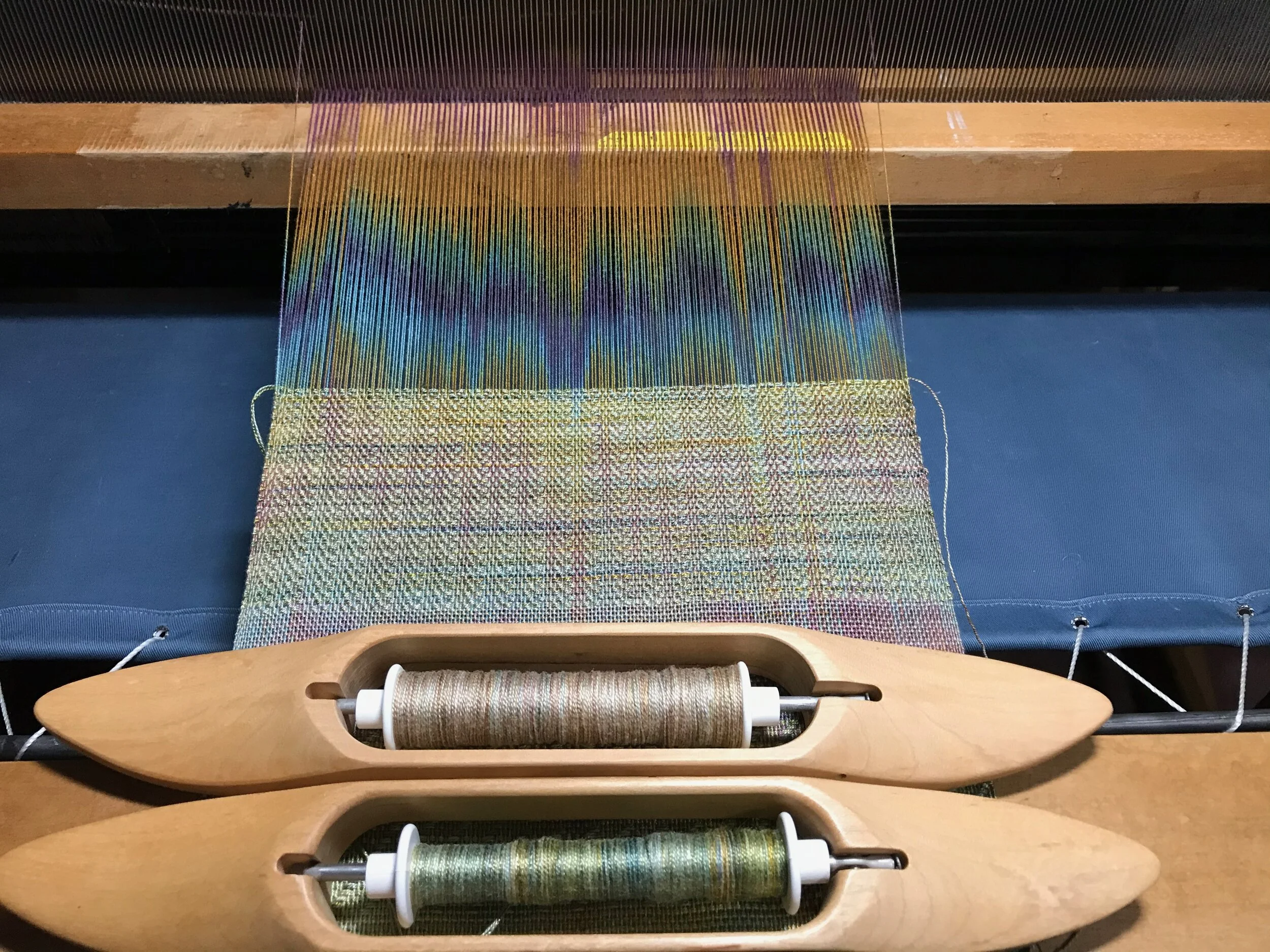 Recent color play on the loom. Using hand dyed yarns to optically mix. Absolutely no plans for this other than to make cloth and use up bundles of warp threads (the rainbow colored vertical threads) I found in a box from grad school.