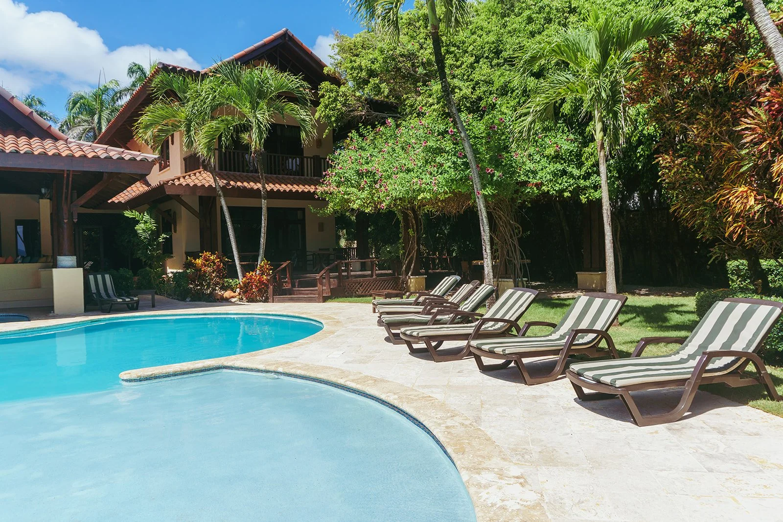 A view of the villa with the pool and lounge chairs.