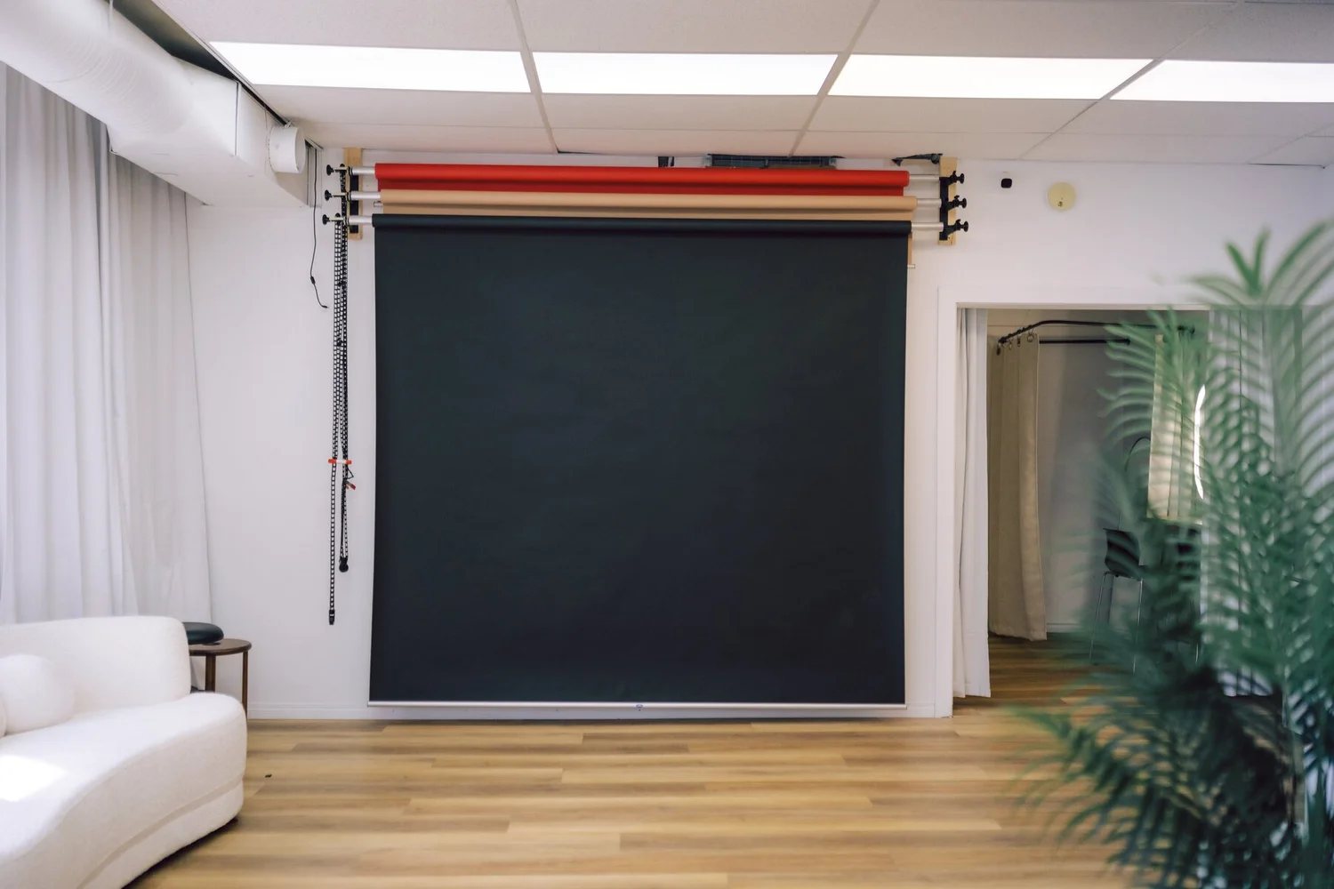 The backdrop wall at Nomadic Studio Co., with red, mocha and black seamless paper on a wall mounted system and the black roll pulled down