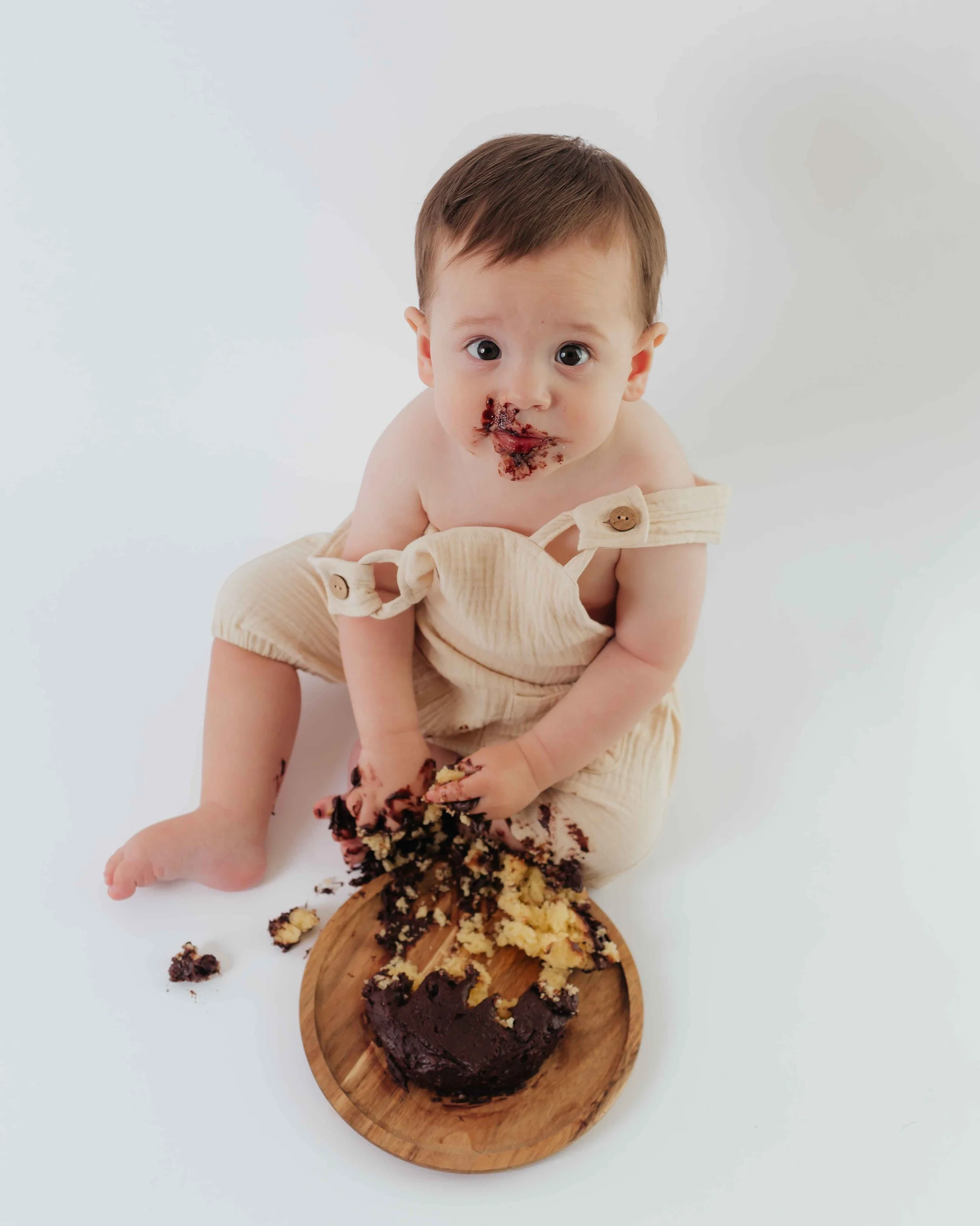dazzling baby eyes after gobbling up delicious chocolate cake for 1st birthday photos