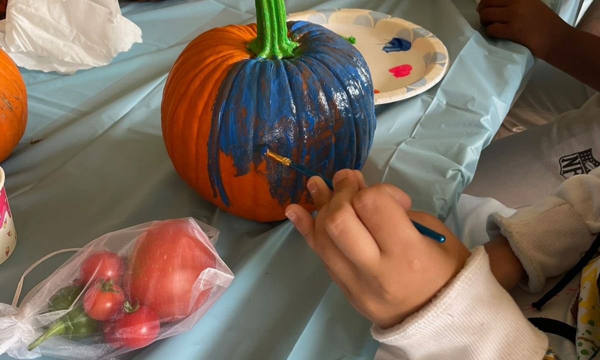 Child painting a pumpkin