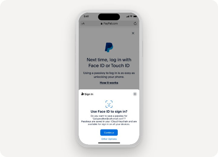 Smartphone screen shows PayPal login page prompting user to log in with passkey.