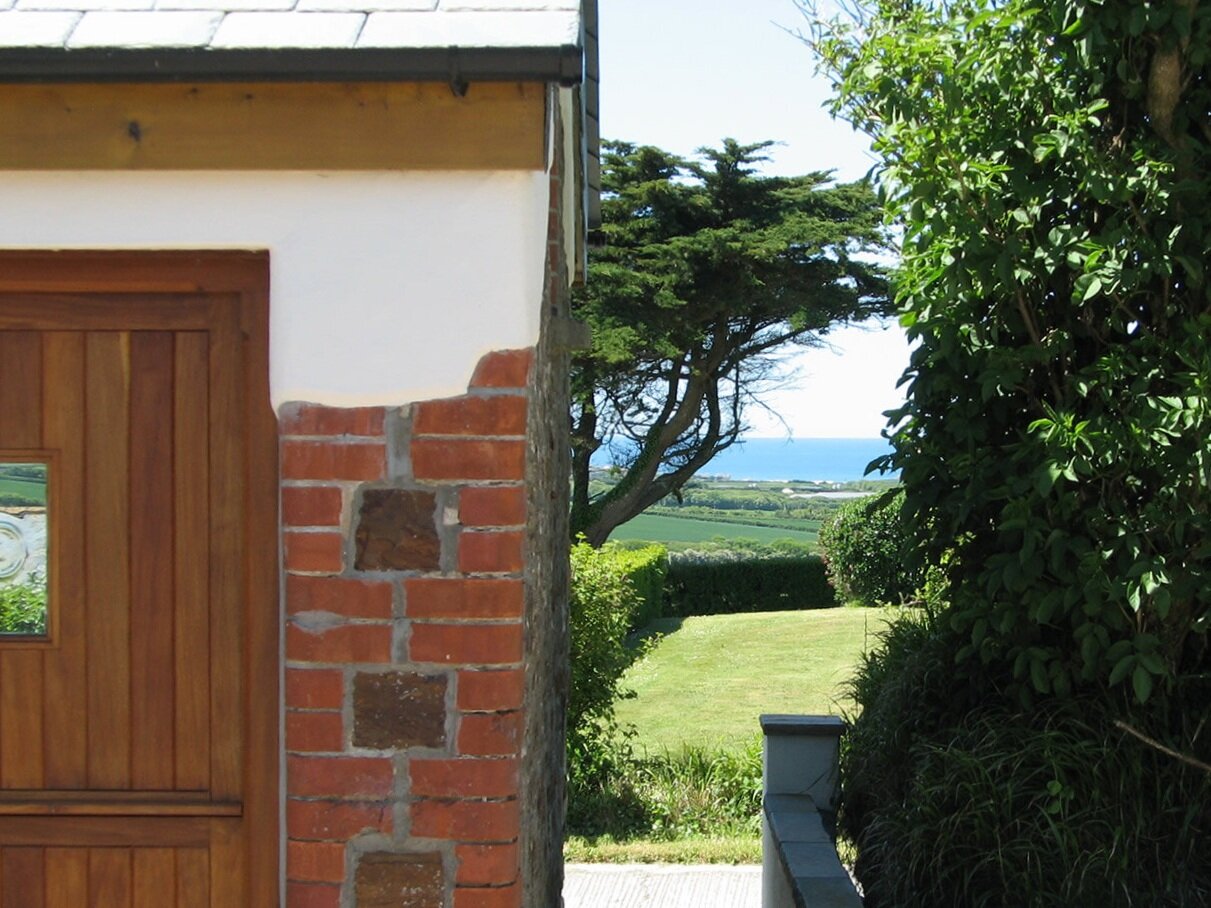 Exterior of Wenna's Well with stable door and sea view