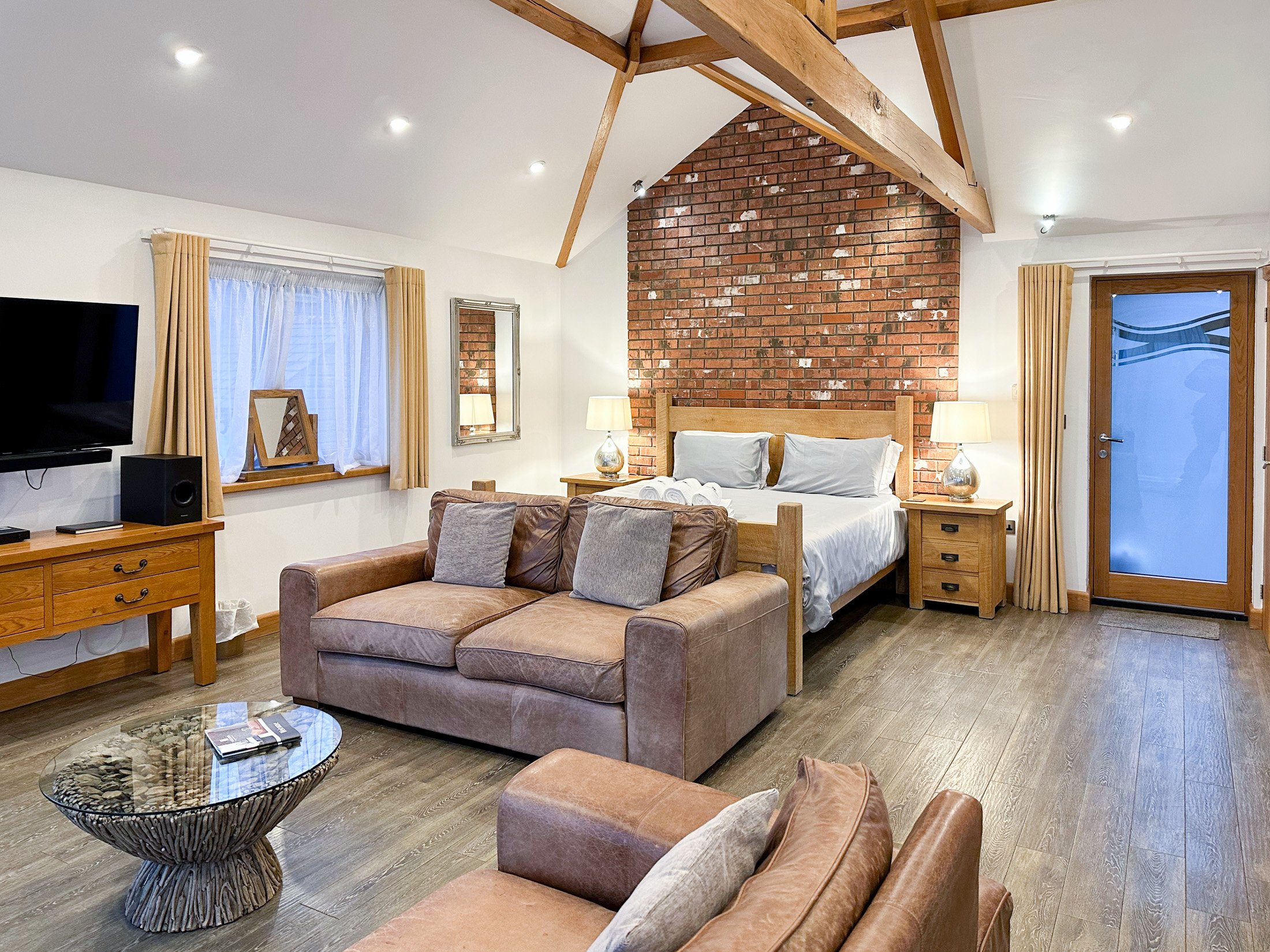 Open plan living with super-king size bed and chunky oak beams