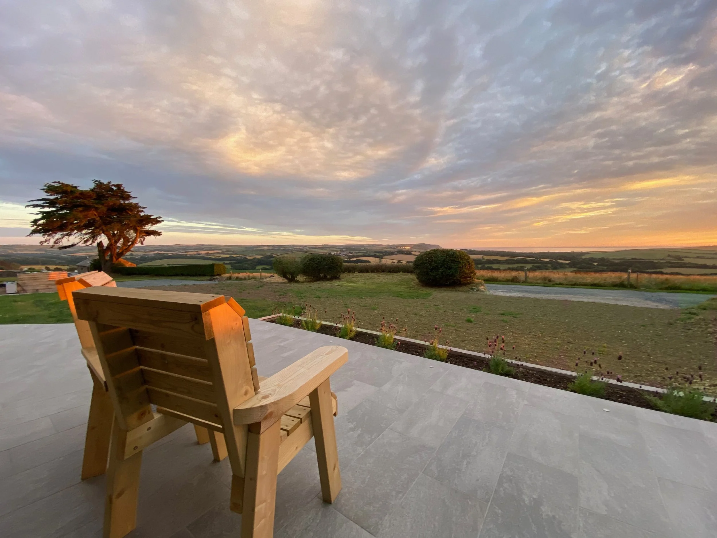 Patio area seating for two to enjoy a sunset sea view
