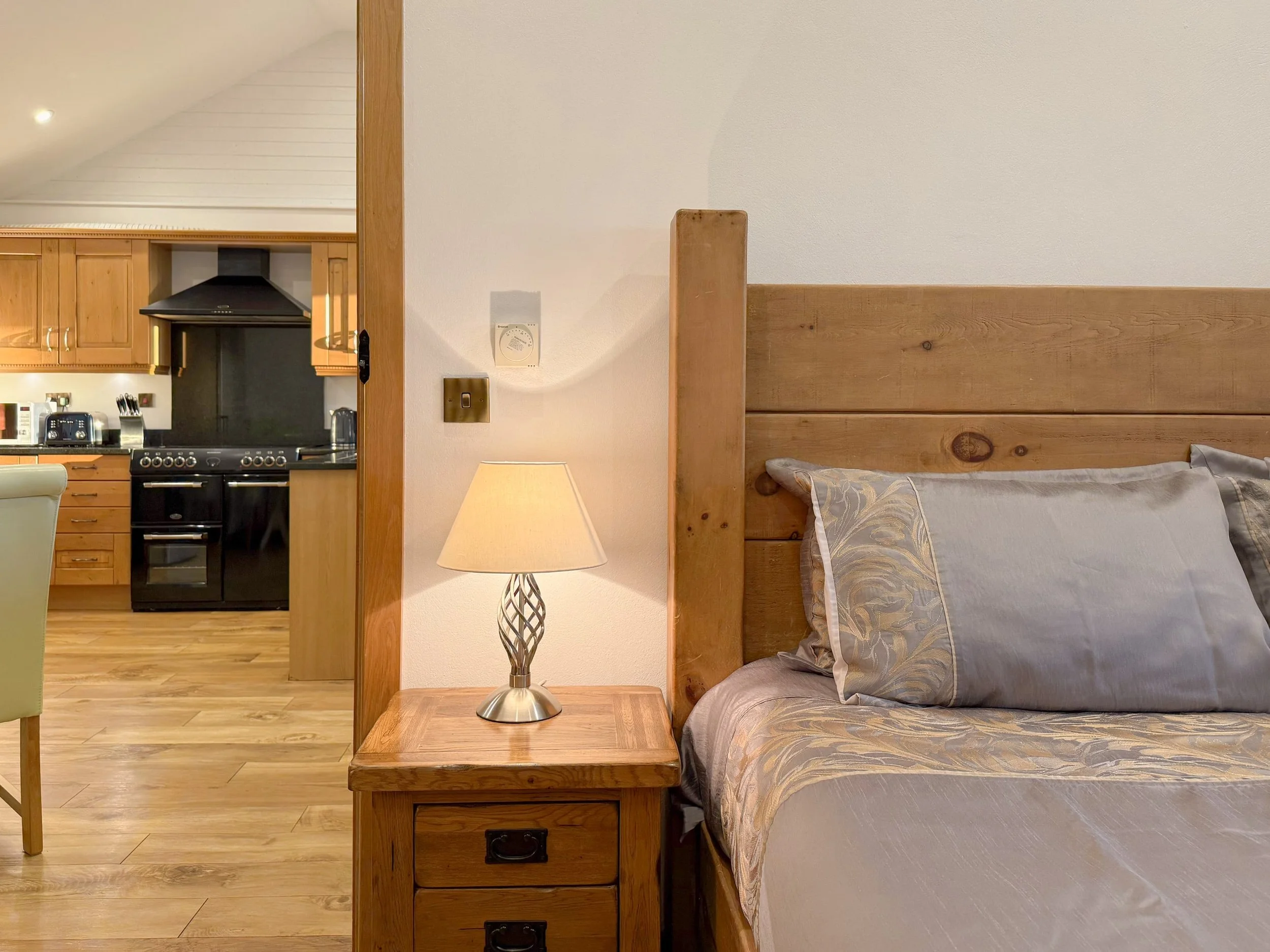 Bedroom looking into main living area with kitchen