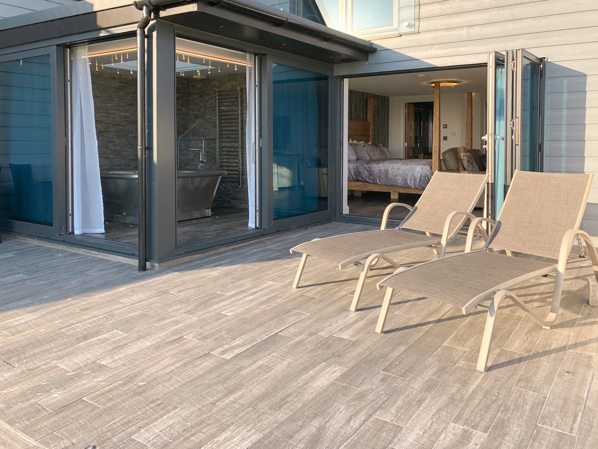 Bi-folding and sliding doors open to patio area with sea views