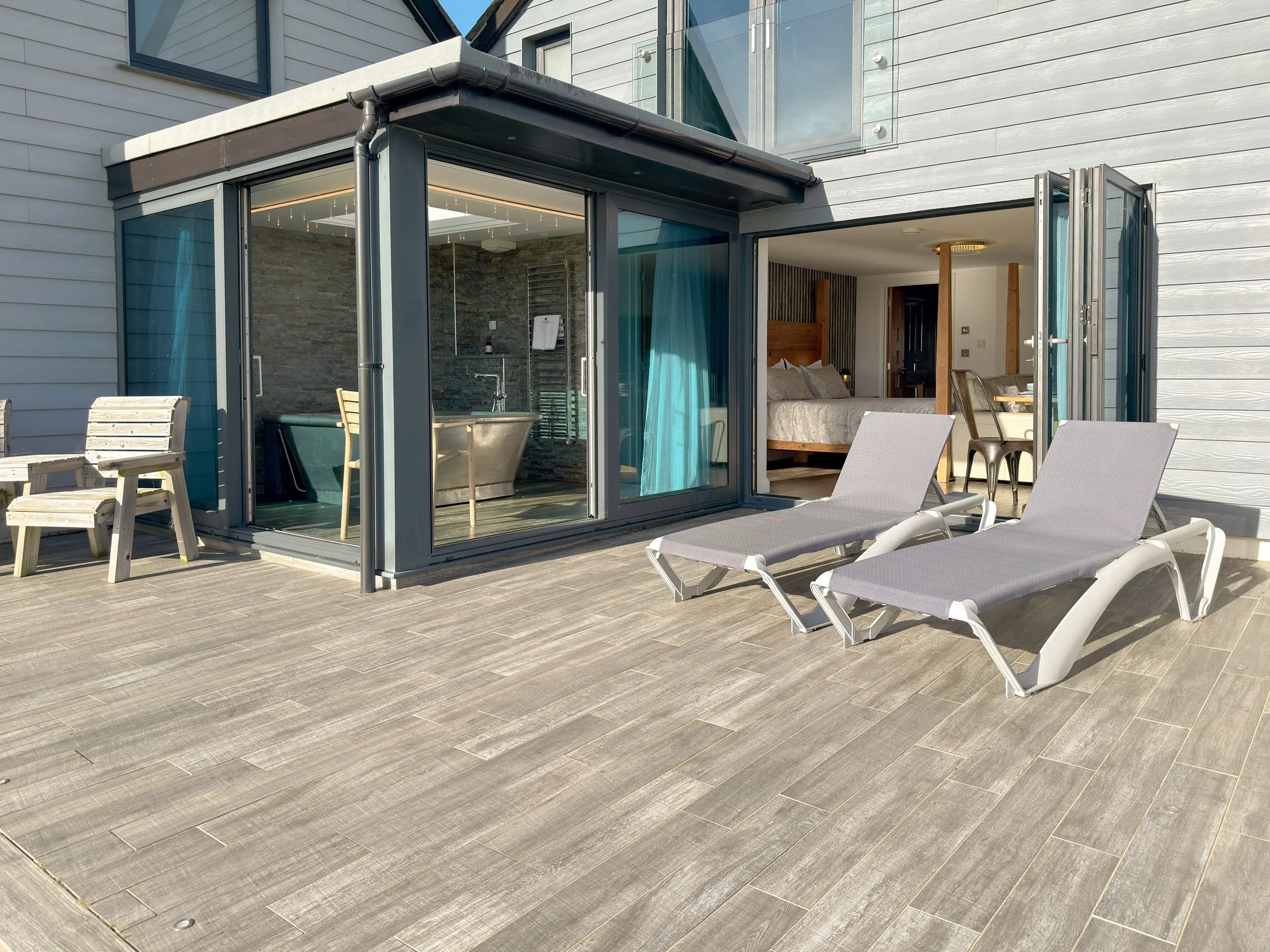 Bi-folding and sliding doors open to patio area with sea views