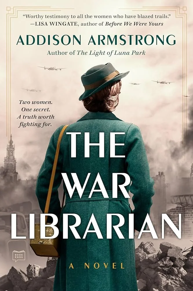 Book cover of "The War Librarian" by Addison Armstrong featuring a woman in a green coat and hat, carrying a yellow bag, with war planes flying in the cloudy sky background and ruins at the bottom.