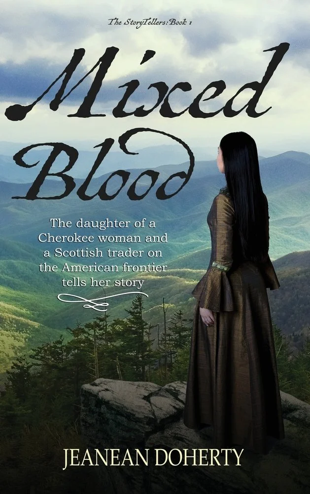 Book cover titled 'Mixed Blood' by Jeanean Doherty, featuring a woman with long black hair wearing a historical dress, standing on rocks overlooking a mountainous landscape with trees and cloudy sky.