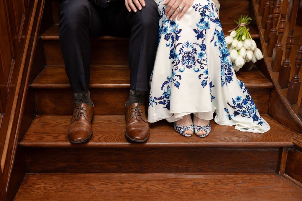 a recently married couple sits on a gorgeous, dark wood, historic staircase in the Moore House