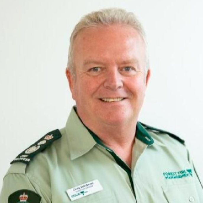 A man with short, grey hair and in a green uniform.