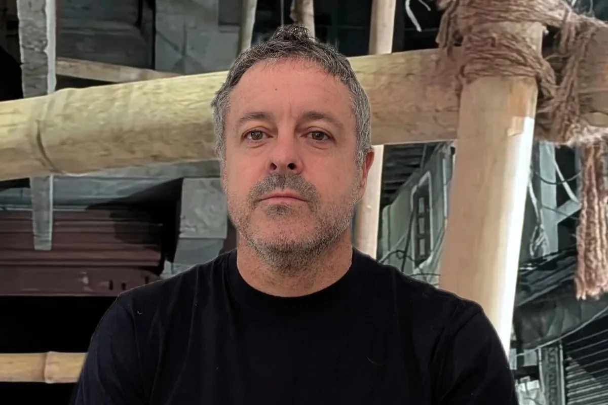 Dylan Martorell in a black shirt in front of a bamboo structure.