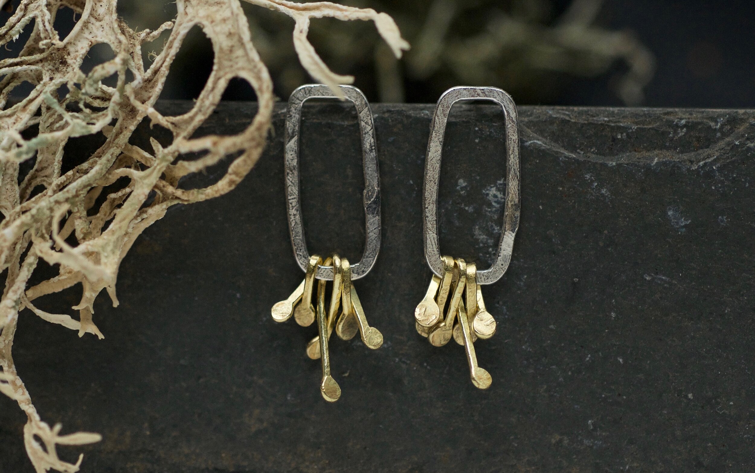 Open silver rectangle earrings with gold cluster details at the bottom