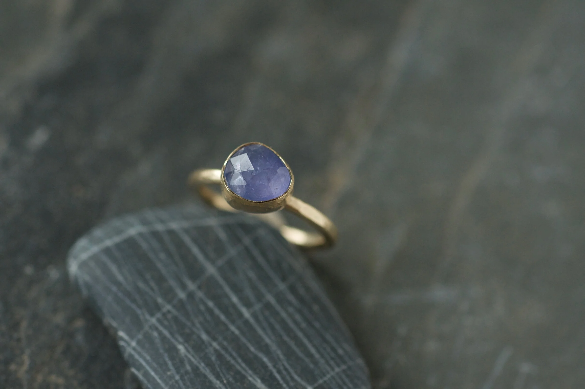blue faceted tanzanite set in gold ring