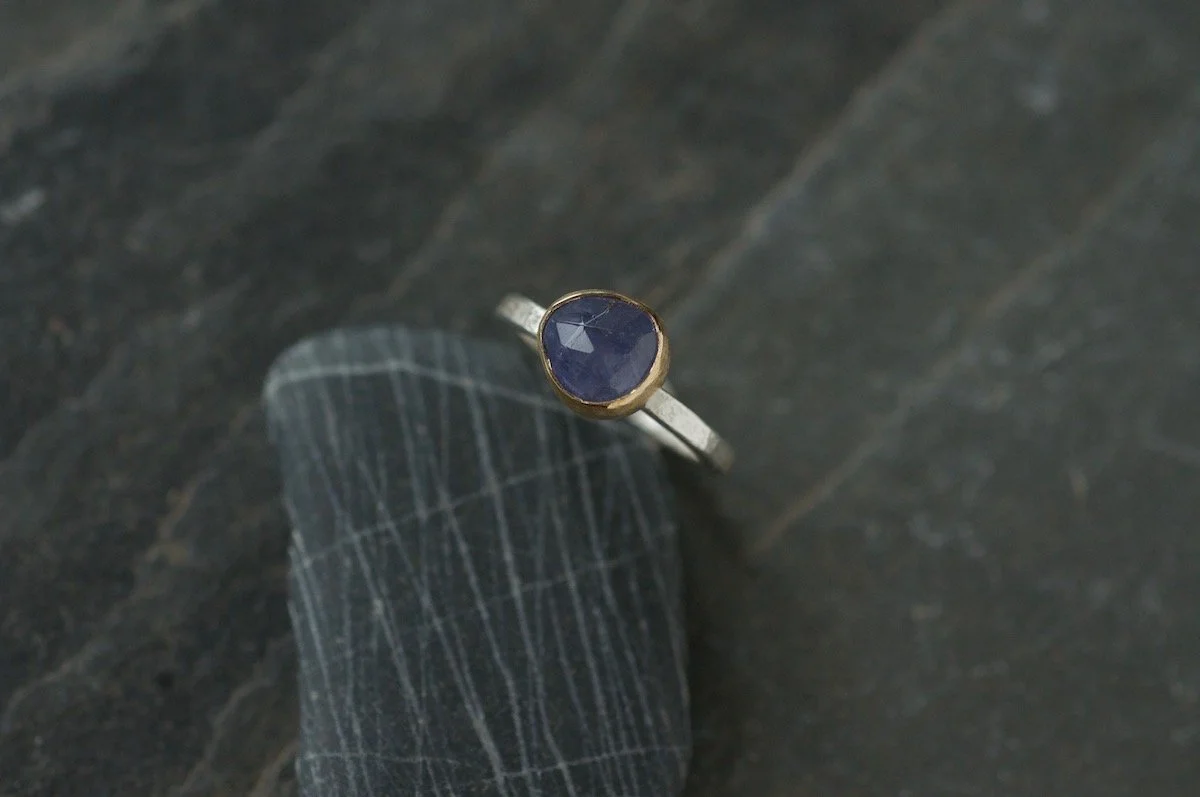 9ct gold and silver tanzanite ring on pebble.jpg