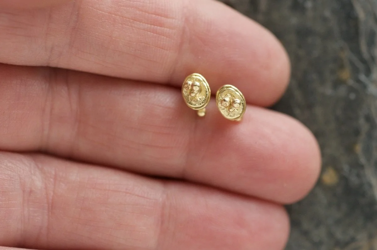 Mini lichen gold vermeil studs in fingers.jpeg