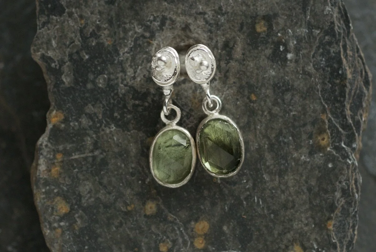 Mini lichen studs with peridot and ludwigite drops on slate.jpeg