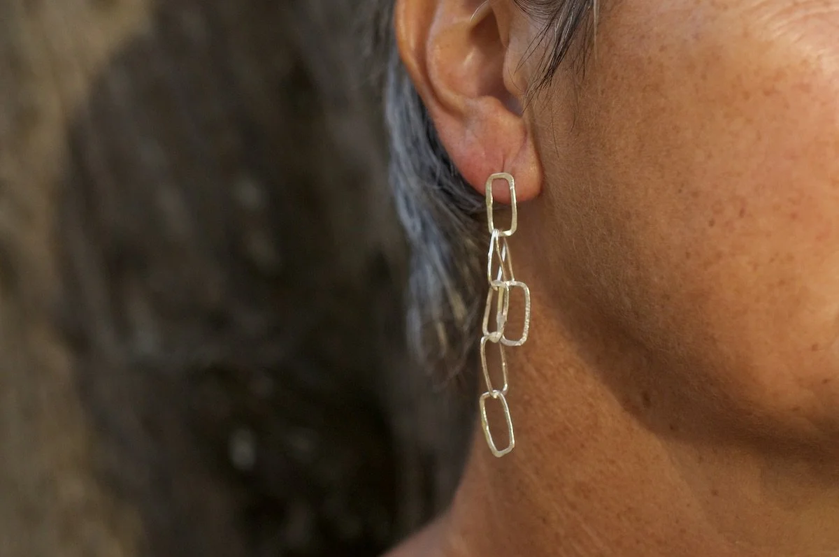 Model wearing mini monolith chain earrings
