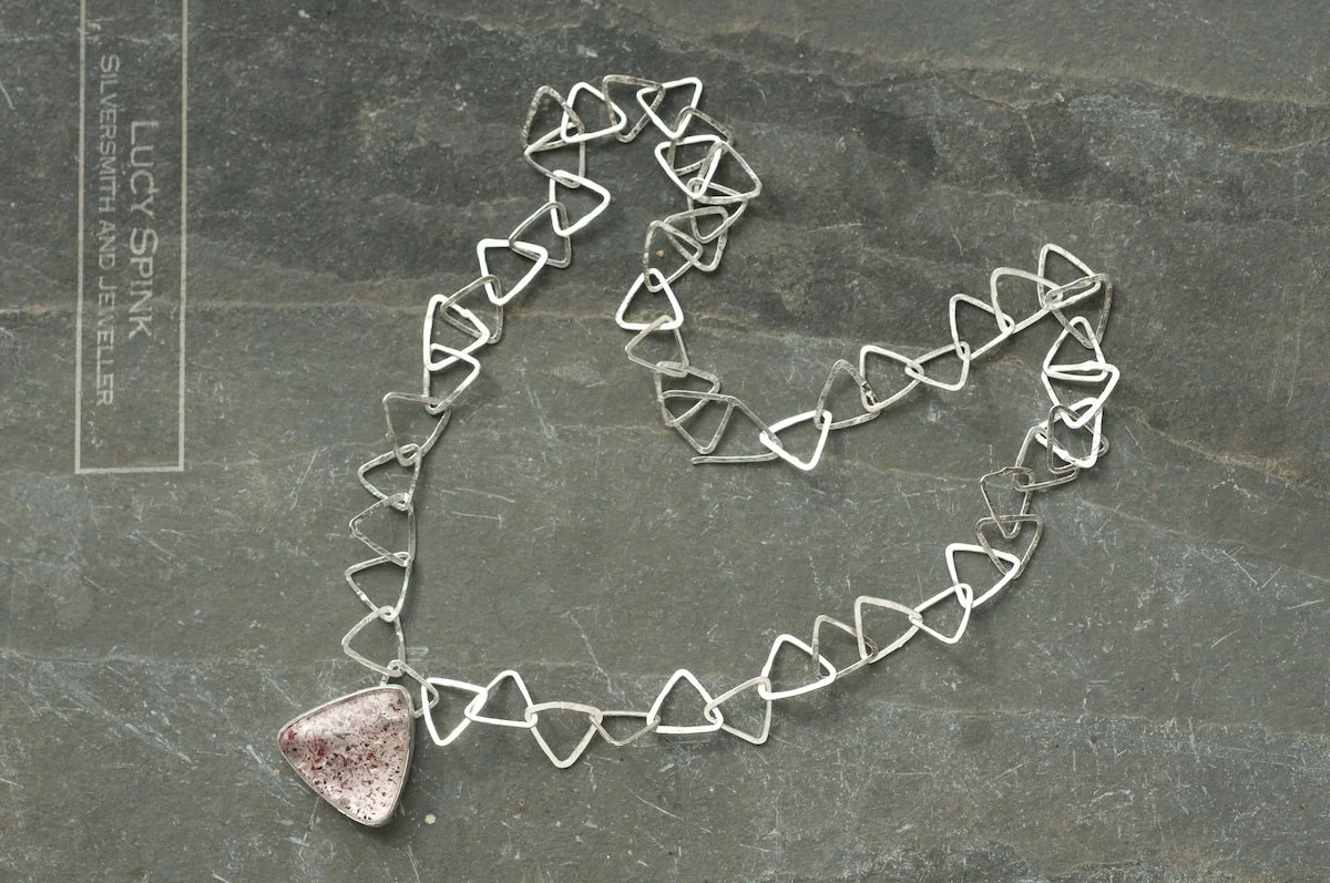 Fire quartz Triangle necklace with triangle link chain flat lay.jpeg
